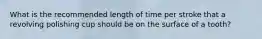 What is the recommended length of time per stroke that a revolving polishing cup should be on the surface of a tooth?