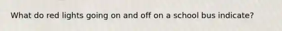 What do red lights going on and off on a school bus indicate?