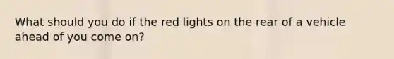 What should you do if the red lights on the rear of a vehicle ahead of you come on?