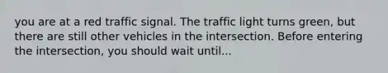 you are at a red traffic signal. The traffic light turns green, but there are still other vehicles in the intersection. Before entering the intersection, you should wait until...