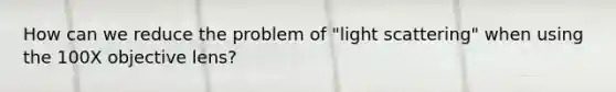 How can we reduce the problem of "light scattering" when using the 100X objective lens?