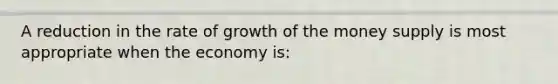 A reduction in the rate of growth of the money supply is most appropriate when the economy is: