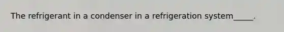 The refrigerant in a condenser in a refrigeration system_____.
