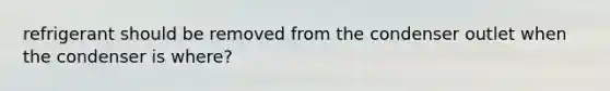 refrigerant should be removed from the condenser outlet when the condenser is where?