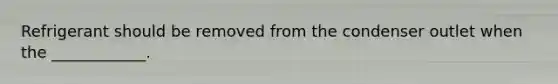Refrigerant should be removed from the condenser outlet when the ____________.