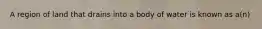 A region of land that drains into a body of water is known as a(n)