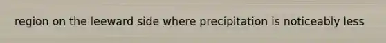 region on the leeward side where precipitation is noticeably less