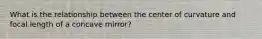 What is the relationship between the center of curvature and focal length of a concave mirror?