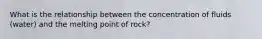 What is the relationship between the concentration of fluids (water) and the melting point of rock?