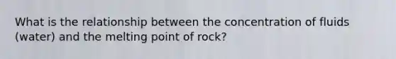 What is the relationship between the concentration of fluids (water) and the melting point of rock?