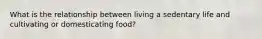 What is the relationship between living a sedentary life and cultivating or domesticating food?