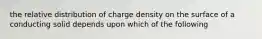 the relative distribution of charge density on the surface of a conducting solid depends upon which of the following