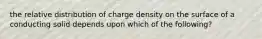 the relative distribution of charge density on the surface of a conducting solid depends upon which of the following?