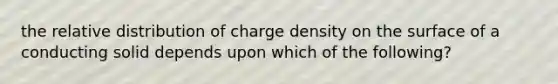 the relative distribution of charge density on the surface of a conducting solid depends upon which of the following?