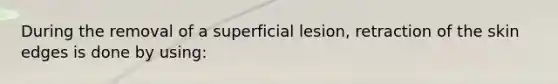 During the removal of a superficial lesion, retraction of the skin edges is done by using: