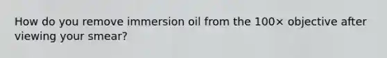 How do you remove immersion oil from the 100× objective after viewing your smear?