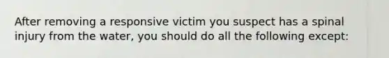 After removing a responsive victim you suspect has a spinal injury from the water, you should do all the following except: