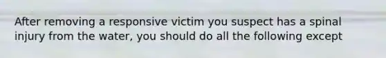 After removing a responsive victim you suspect has a spinal injury from the water, you should do all the following except