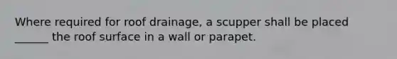 Where required for roof drainage, a scupper shall be placed ______ the roof surface in a wall or parapet.