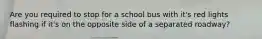 Are you required to stop for a school bus with it's red lights flashing if it's on the opposite side of a separated roadway?