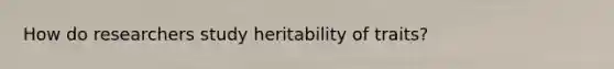 How do researchers study heritability of traits?