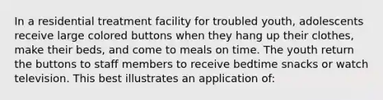 In a residential treatment facility for troubled youth, adolescents receive large colored buttons when they hang up their clothes, make their beds, and come to meals on time. The youth return the buttons to staff members to receive bedtime snacks or watch television. This best illustrates an application of: