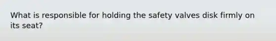 What is responsible for holding the safety valves disk firmly on its seat?