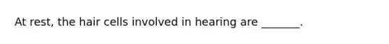 At rest, the hair cells involved in hearing are _______.