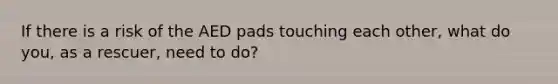 If there is a risk of the AED pads touching each other, what do you, as a rescuer, need to do?