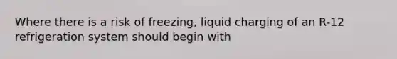 Where there is a risk of freezing, liquid charging of an R-12 refrigeration system should begin with