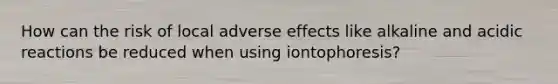 How can the risk of local adverse effects like alkaline and acidic reactions be reduced when using iontophoresis?