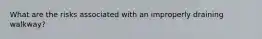 What are the risks associated with an improperly draining walkway?