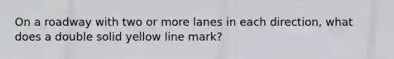 On a roadway with two or more lanes in each direction, what does a double solid yellow line mark?