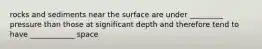 rocks and sediments near the surface are under _________ pressure than those at significant depth and therefore tend to have ____________ space