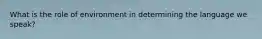What is the role of environment in determining the language we speak?