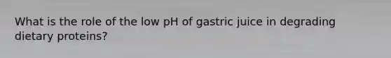 What is the role of the low pH of gastric juice in degrading dietary proteins?