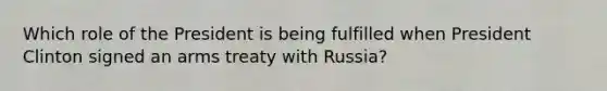 Which role of the President is being fulfilled when President Clinton signed an arms treaty with Russia?