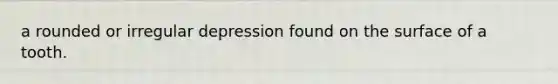 a rounded or irregular depression found on the surface of a tooth.