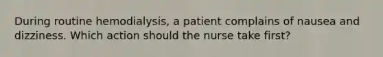 During routine hemodialysis, a patient complains of nausea and dizziness. Which action should the nurse take first?