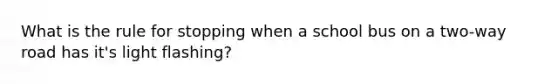 What is the rule for stopping when a school bus on a two-way road has it's light flashing?