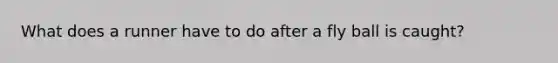 What does a runner have to do after a fly ball is caught?