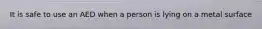 It is safe to use an AED when a person is lying on a metal surface