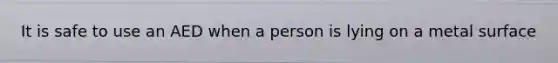 It is safe to use an AED when a person is lying on a metal surface