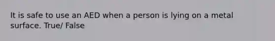 It is safe to use an AED when a person is lying on a metal surface. True/ False