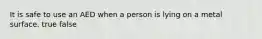 It is safe to use an AED when a person is lying on a metal surface. true false