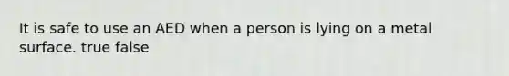 It is safe to use an AED when a person is lying on a metal surface. true false