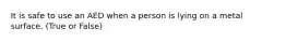 It is safe to use an AED when a person is lying on a metal surface. (True or False)