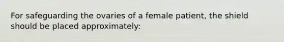 For safeguarding the ovaries of a female patient, the shield should be placed approximately: