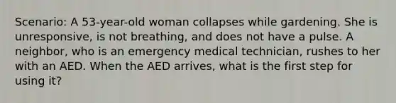 Scenario: A 53-year-old woman collapses while gardening. She is unresponsive, is not breathing, and does not have a pulse. A neighbor, who is an emergency medical technician, rushes to her with an AED. When the AED arrives, what is the first step for using it?