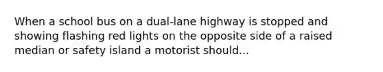 When a school bus on a dual-lane highway is stopped and showing flashing red lights on the opposite side of a raised median or safety island a motorist should...